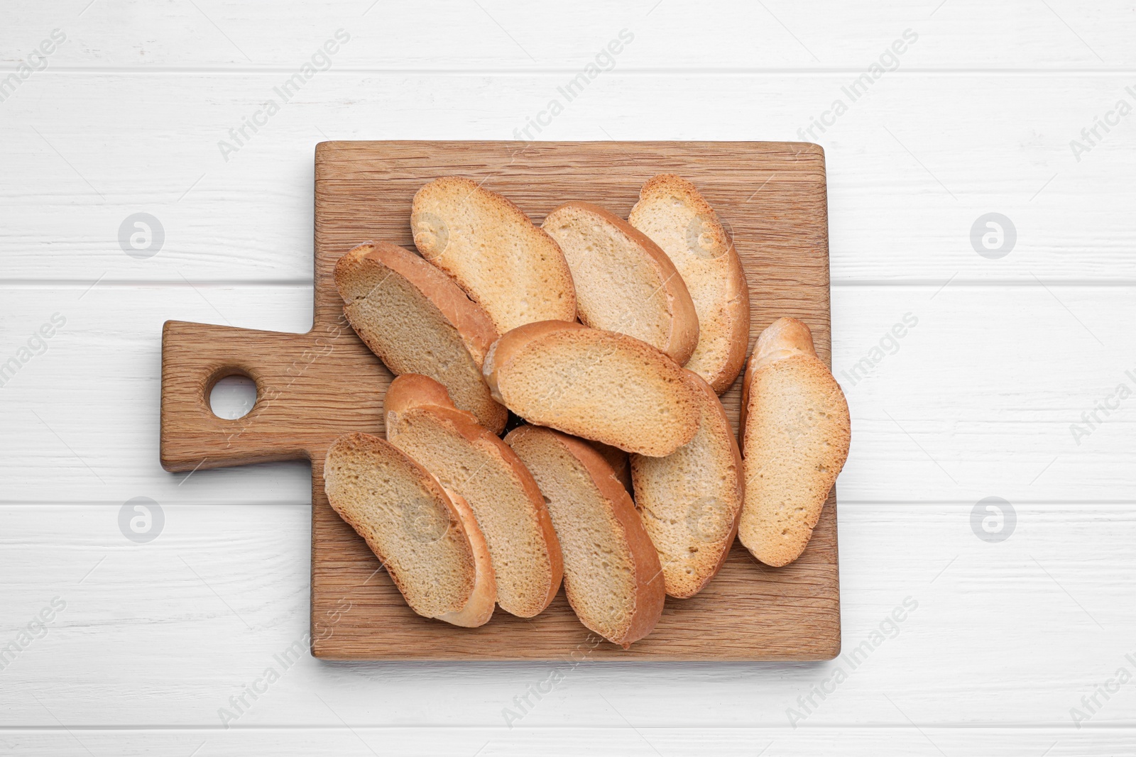 Photo of Tasty hard chuck crackers on white wooden table, top view