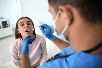 Doctor taking sample for DNA test from woman in clinic