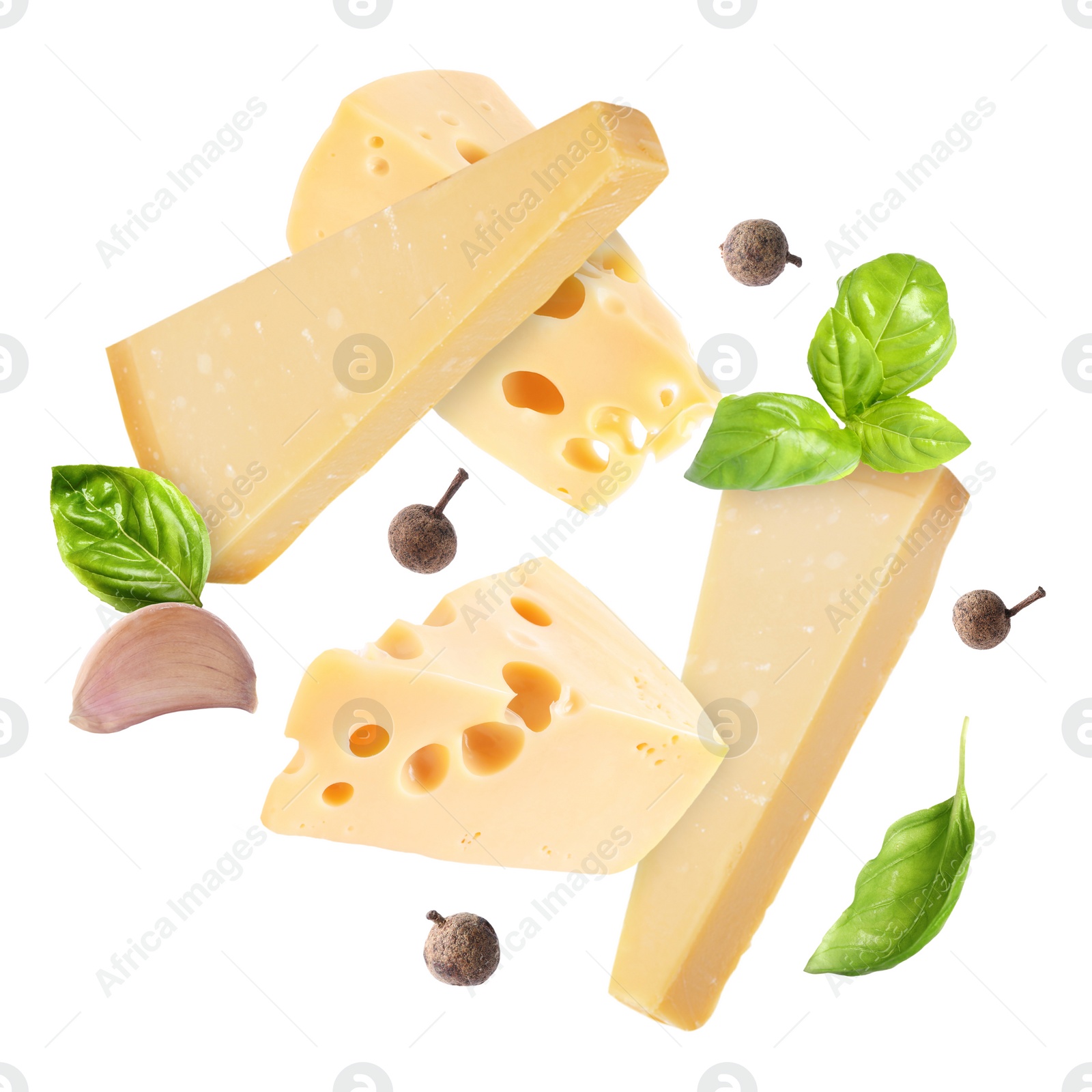 Image of Different kinds of cheese, basil, garlic and allspice falling on white background