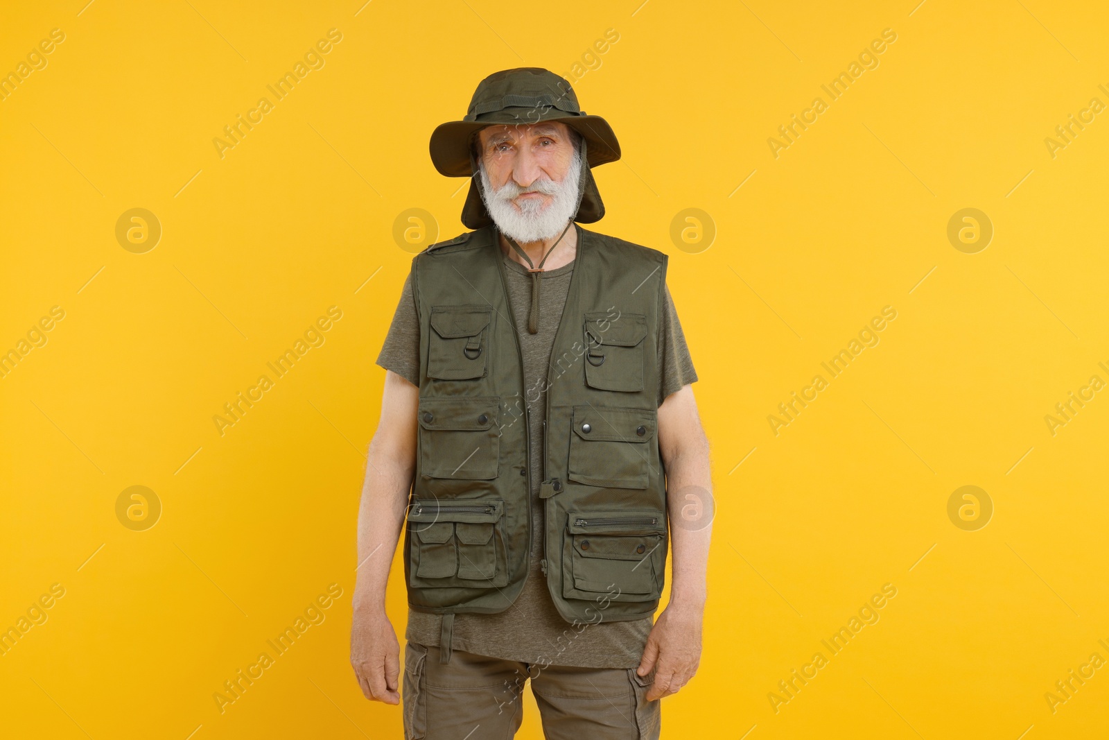 Photo of Portrait of fisherman in hat on yellow background