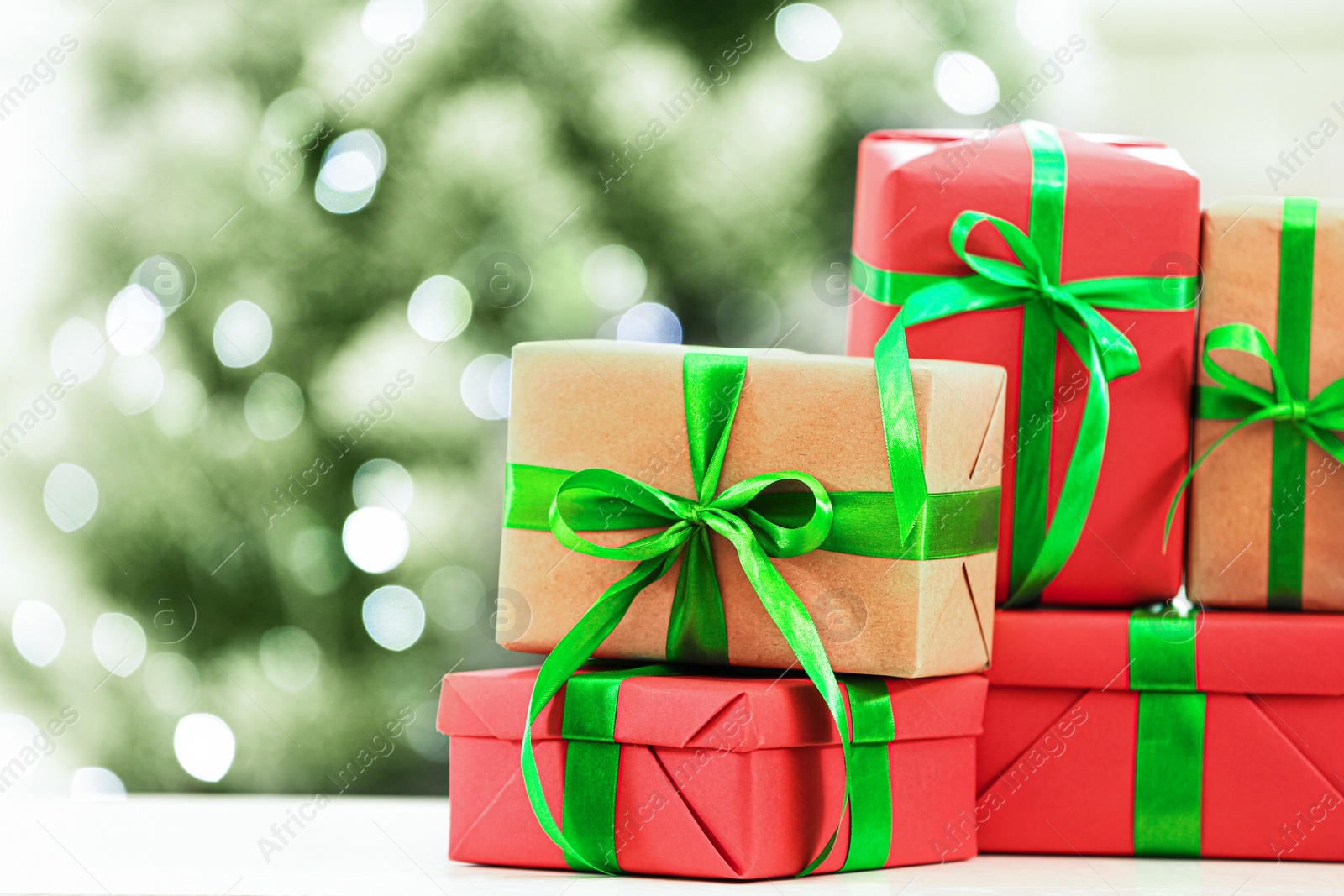 Photo of Christmas gifts on table against blurred background. Space for text