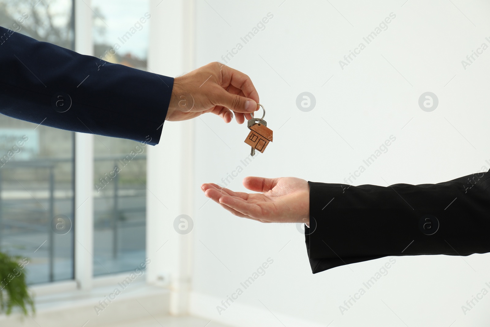Photo of Real estate agent giving key to client in new house, closeup
