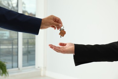 Real estate agent giving key to client in new house, closeup