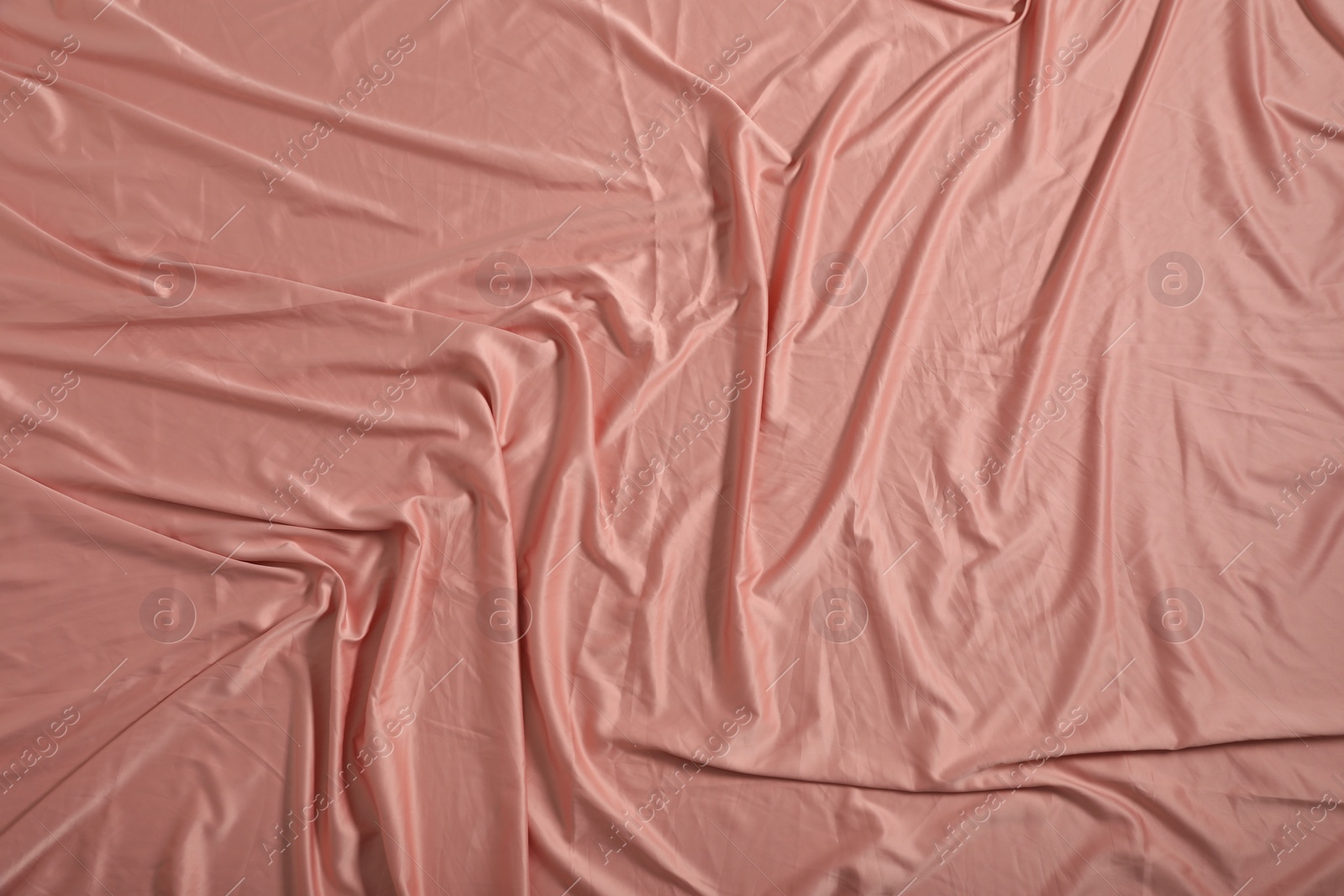 Photo of Crumpled coral fabric as background, closeup view