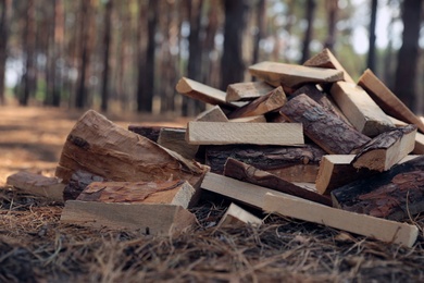 Photo of Pile of cut firewood outdoors. Heating in winter