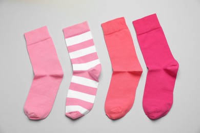 Photo of Different pink socks on light background, flat lay