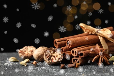 Different spices on grey table, closeup. Cinnamon, anise, cloves, cardamom, nutmegs