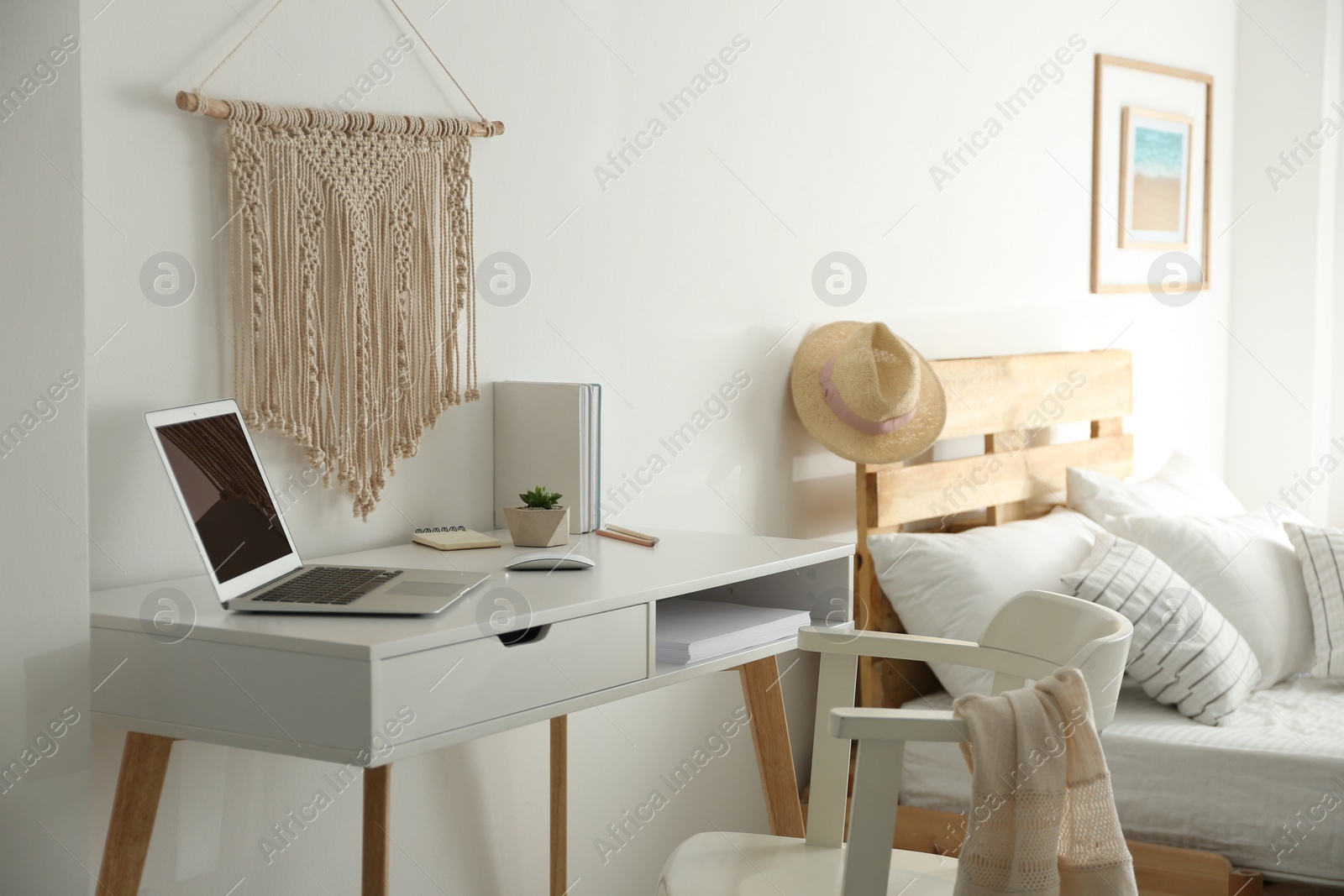 Photo of Stylish room interior with workplace and bed