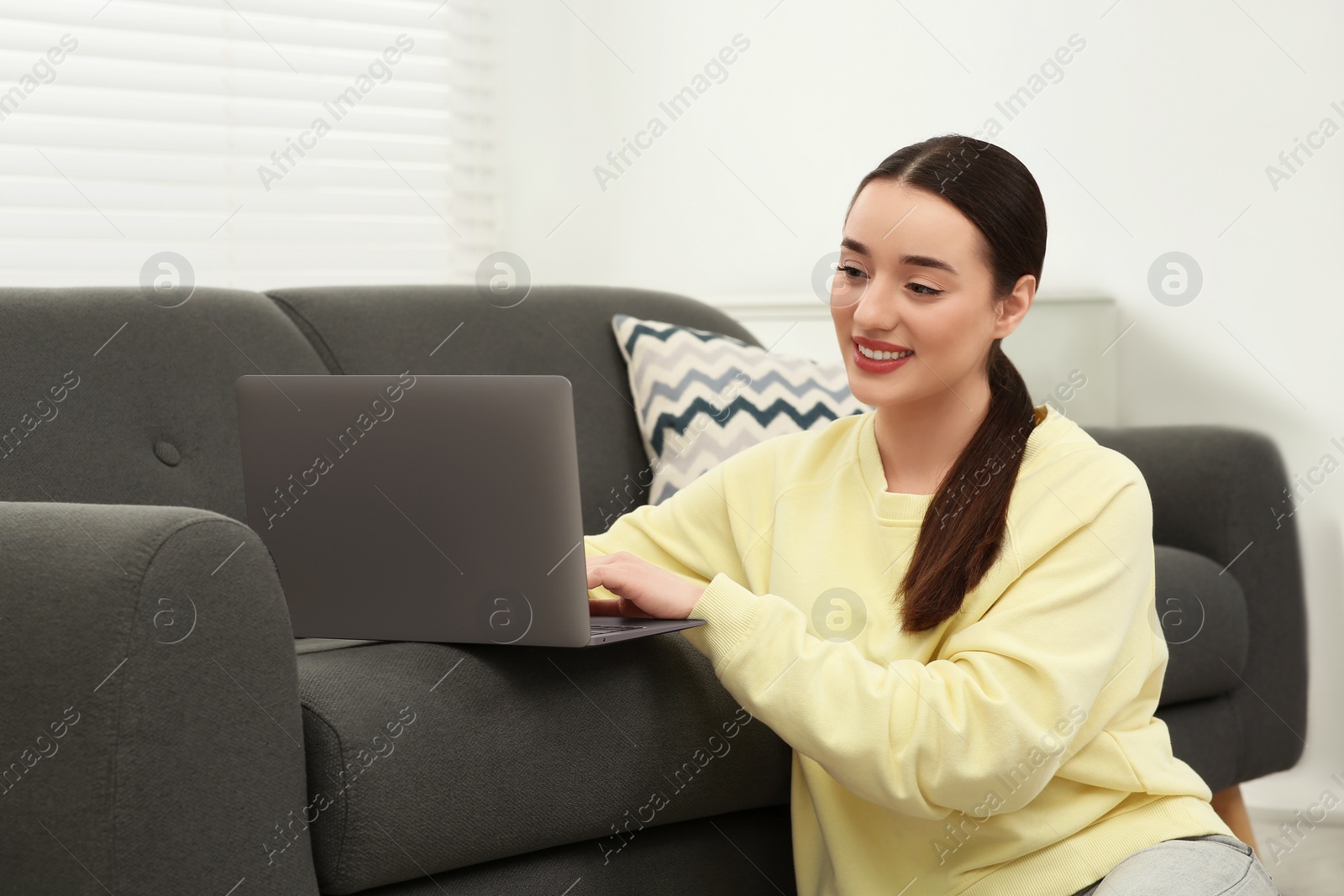 Photo of Woman using laptop on couch at home