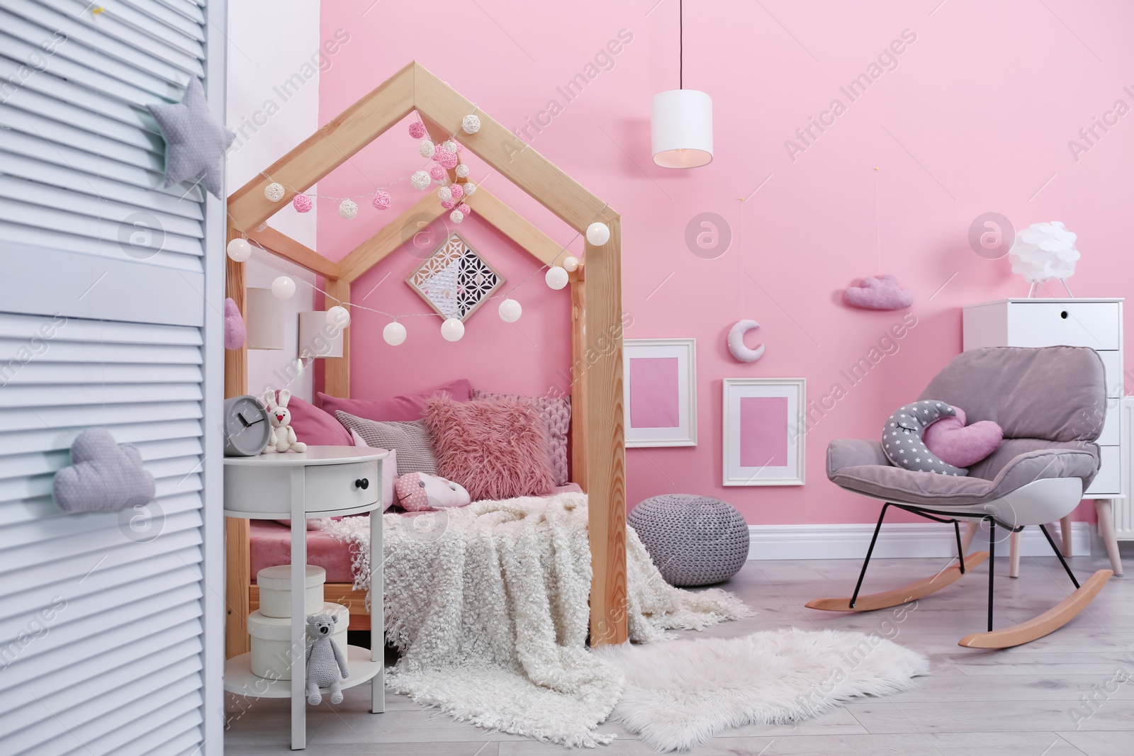 Photo of Child's room interior with comfortable bed and garland