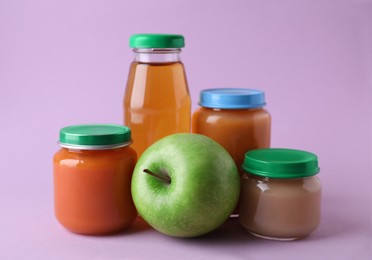 Healthy baby food, juice and apple on lilac background