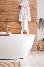 Photo of White tub and beautiful plants in bathroom, Interior design