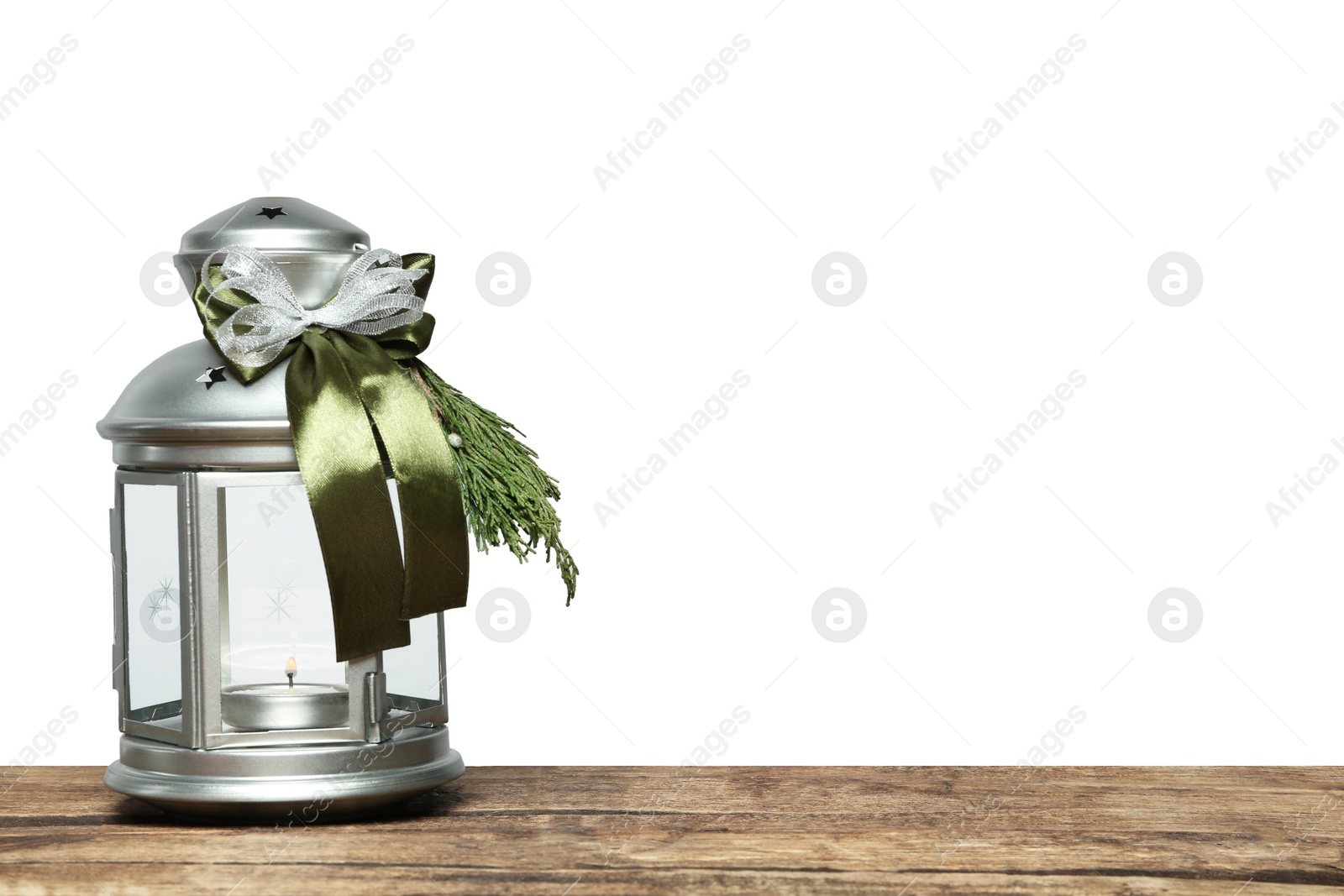 Photo of Decorated Christmas lantern with burning candle on wooden table, space for text