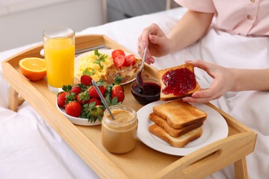 Photo of Woman having tasty breakfast in bed, closeup