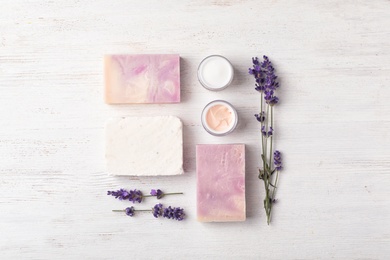 Photo of Flat lay composition with handmade soap bars and ingredients on white wooden background