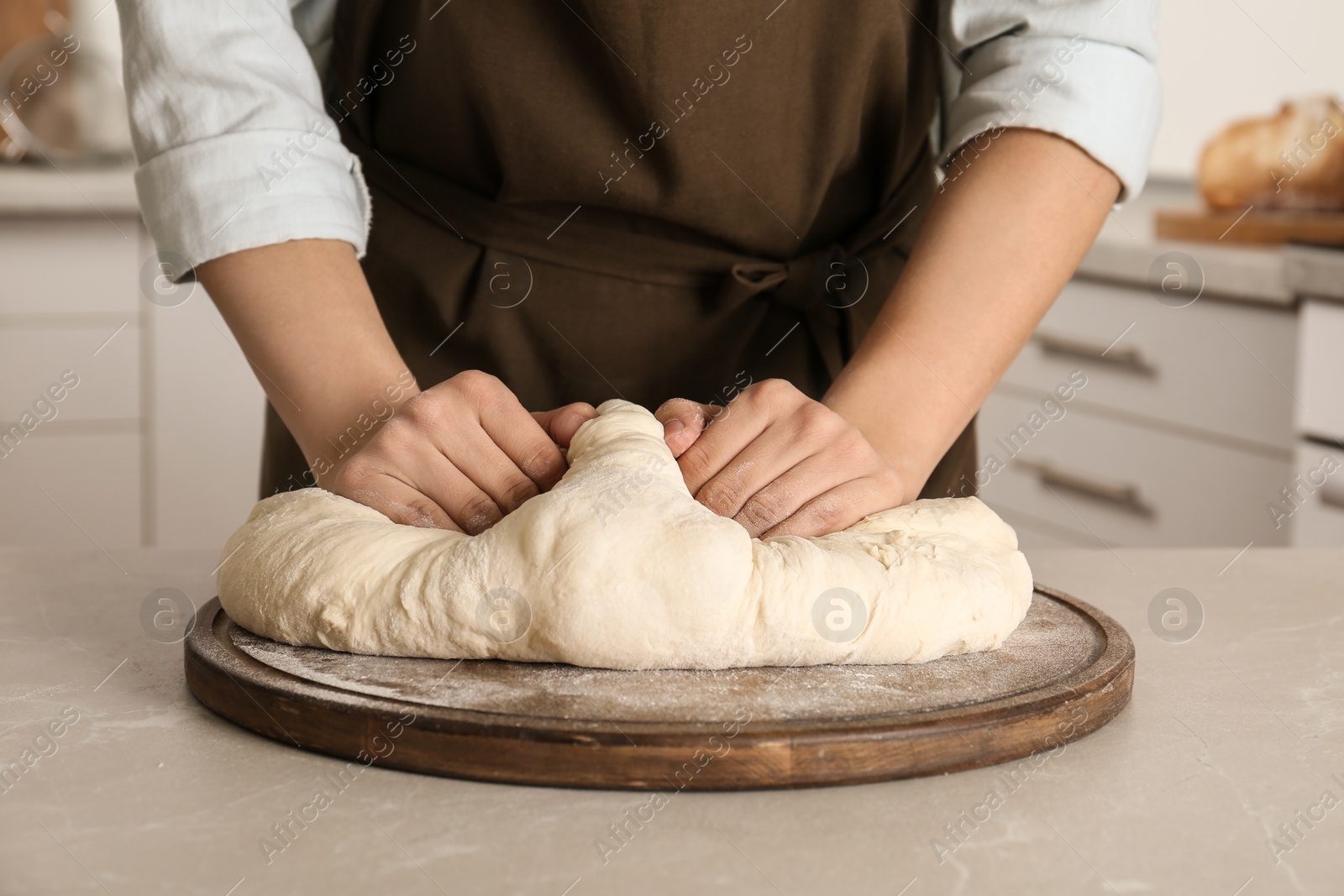 Photo of Female baker preparing bread dough at table, closeup