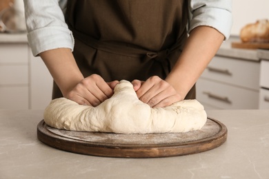 Female baker preparing bread dough at table, closeup