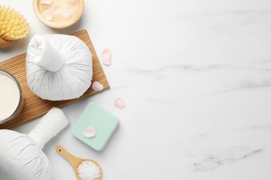 Flat lay composition with different spa products on white marble table. Space for text