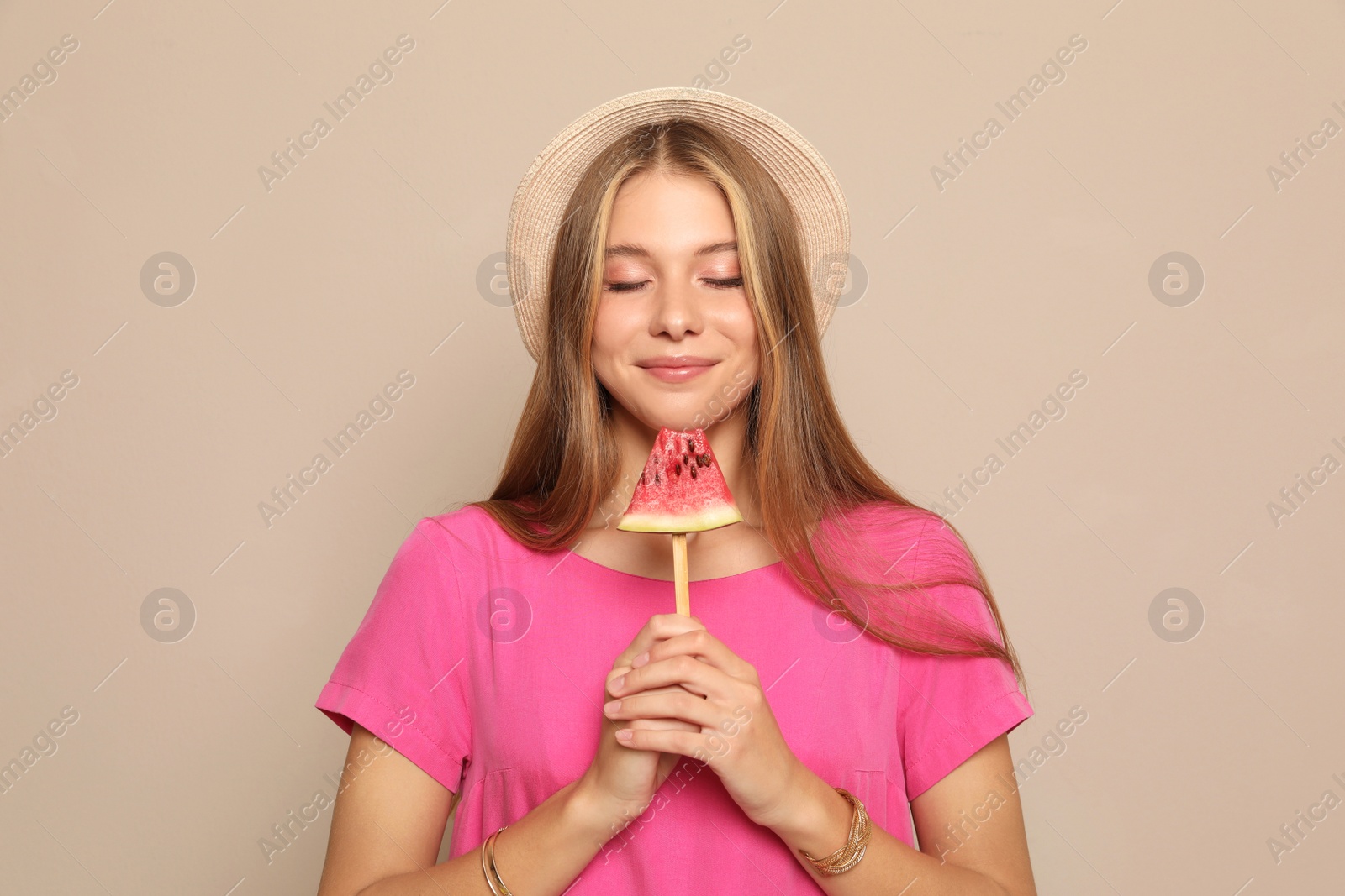 Photo of Beautiful girl with pieces of watermelon on beige background