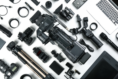 Photo of Flat lay composition with video camera and other equipment on white background