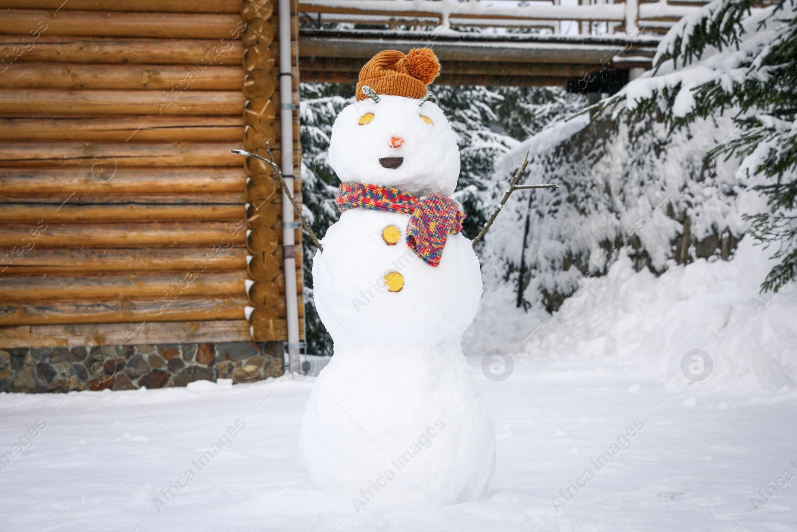 Photo of Funny snowman with hat and scarf outdoors. Winter vacation