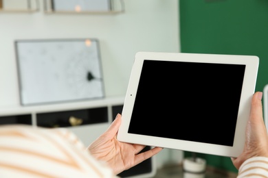 Photo of Woman using video chat on tablet at home, closeup. Space for text