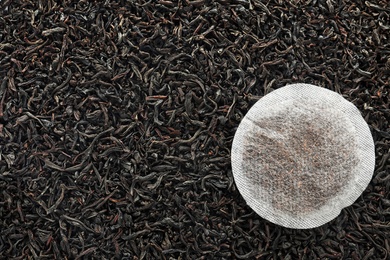 Tea bag on dry leaves, top view with space for text