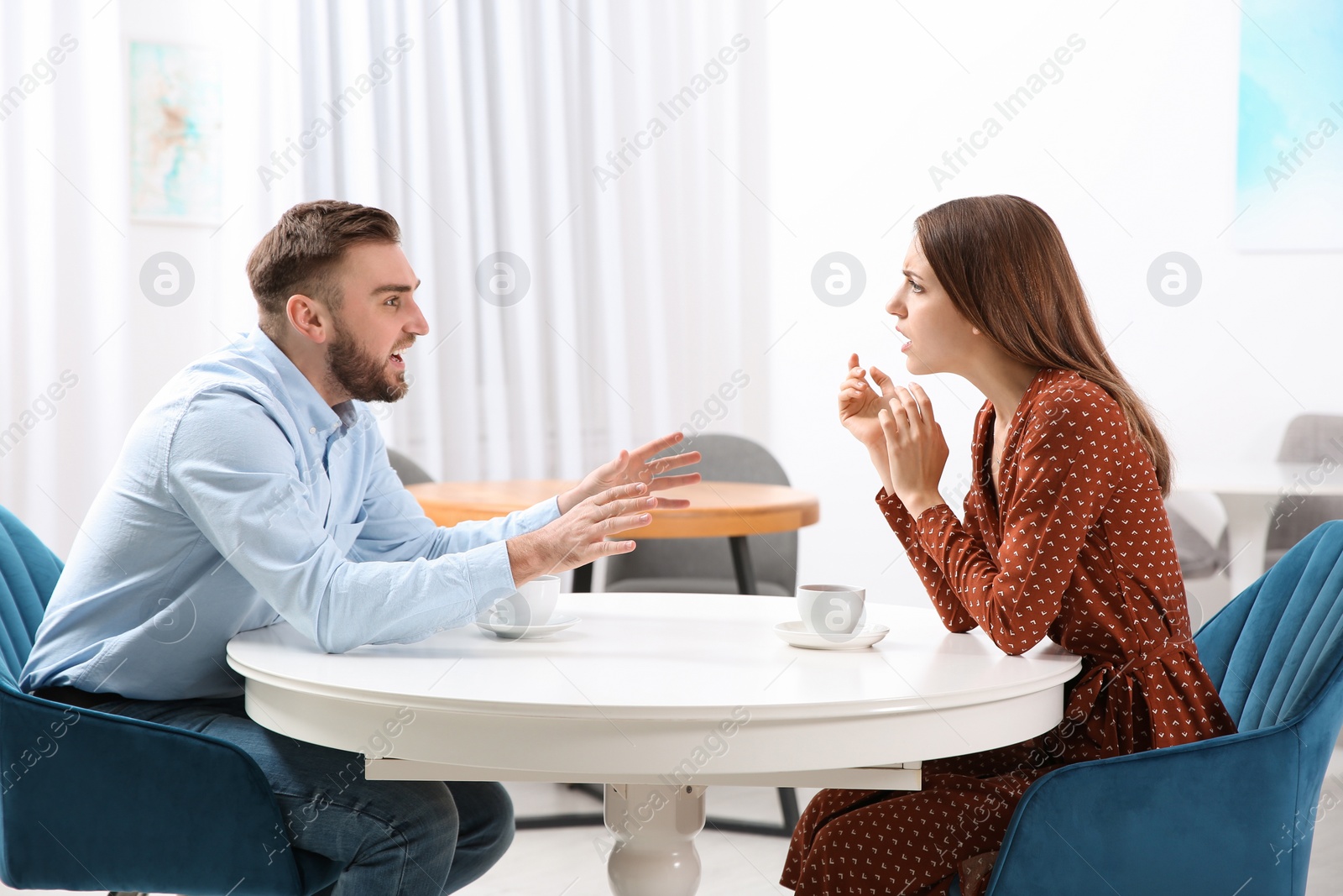 Photo of Couple having quarrel in cafe. Relationship problems