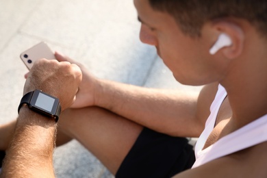 Man checking fitness tracker after training outdoors, closeup