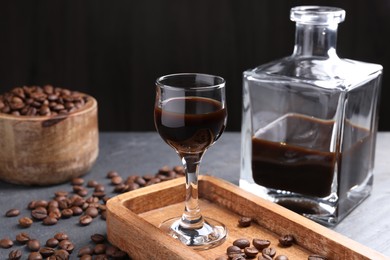 Photo of Coffee liqueur and beans on grey table