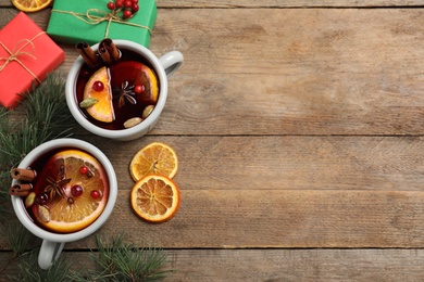 Flat lay composition with tasty mulled wine on wooden table. Space for text