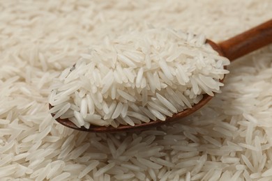 Raw basmati rice and spoon as background, closeup