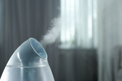 Photo of Modern air humidifier indoors, closeup. Space for text