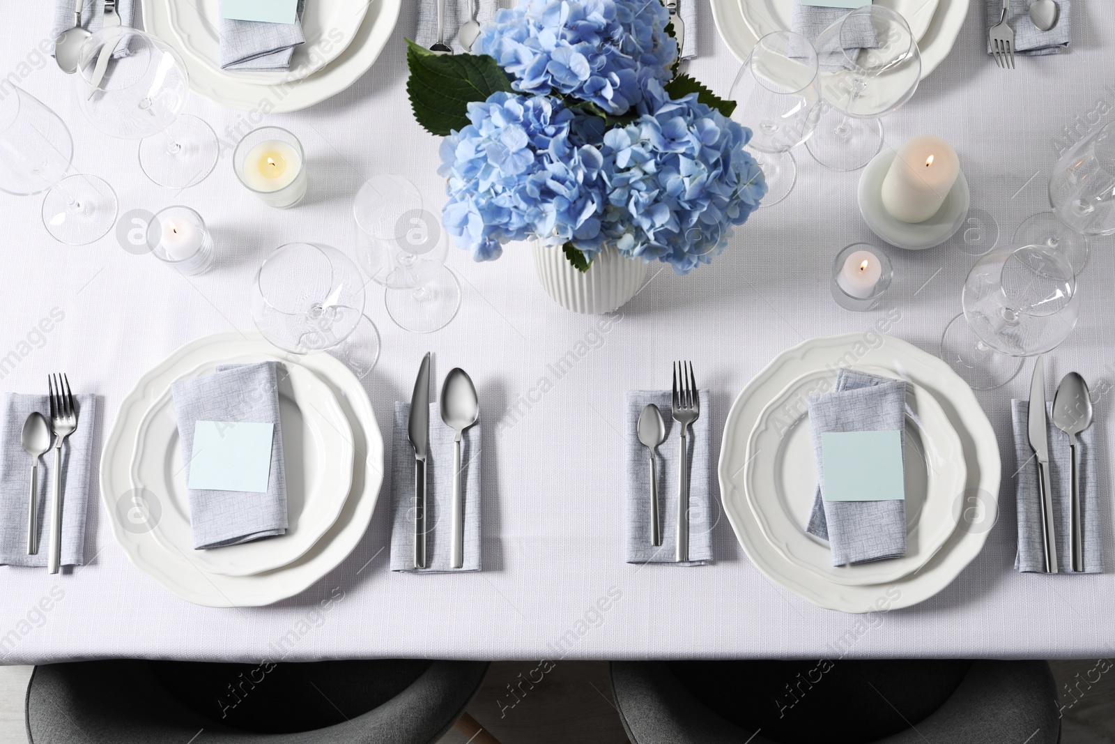 Photo of Beautiful table setting with blank cards and floral decor, top view