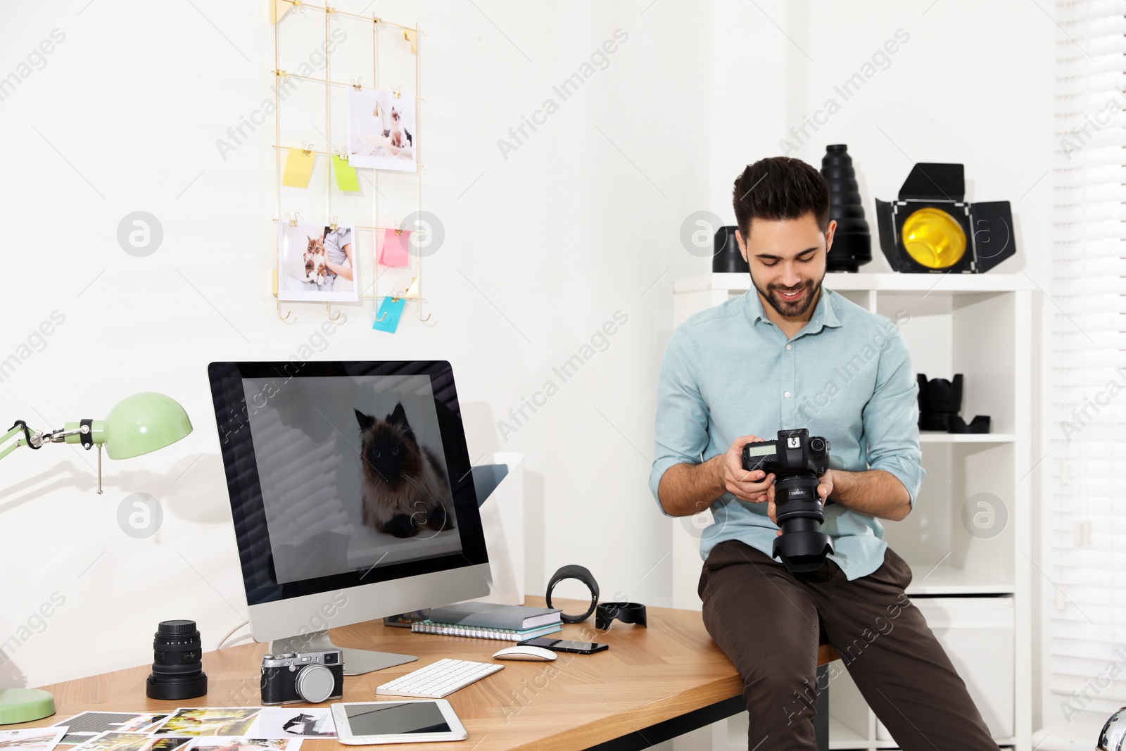 Photo of Professional photographer with camera working in light modern office