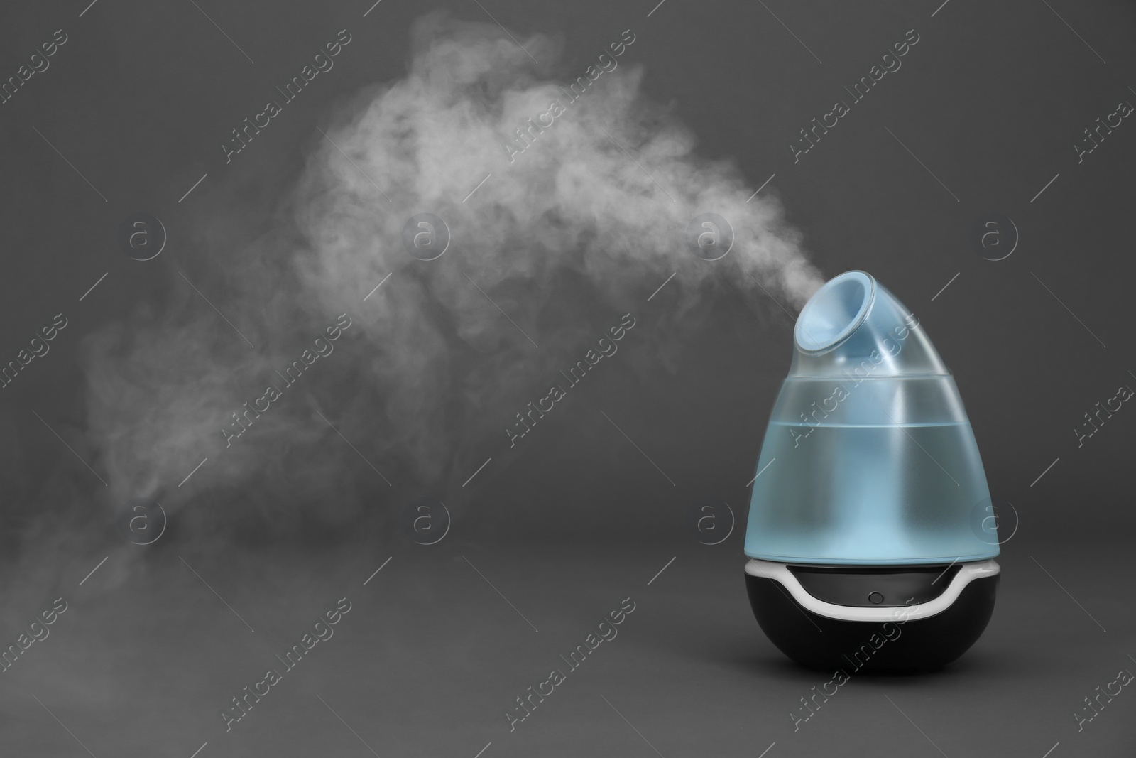 Photo of Modern air humidifier on grey background. Space for text