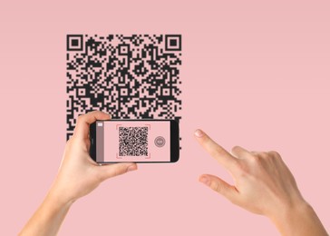 Image of Woman scanning QR code with smartphone on pink background, closeup