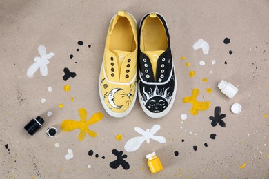 Photo of Amazing customized shoes and painting supplies on color background, flat lay