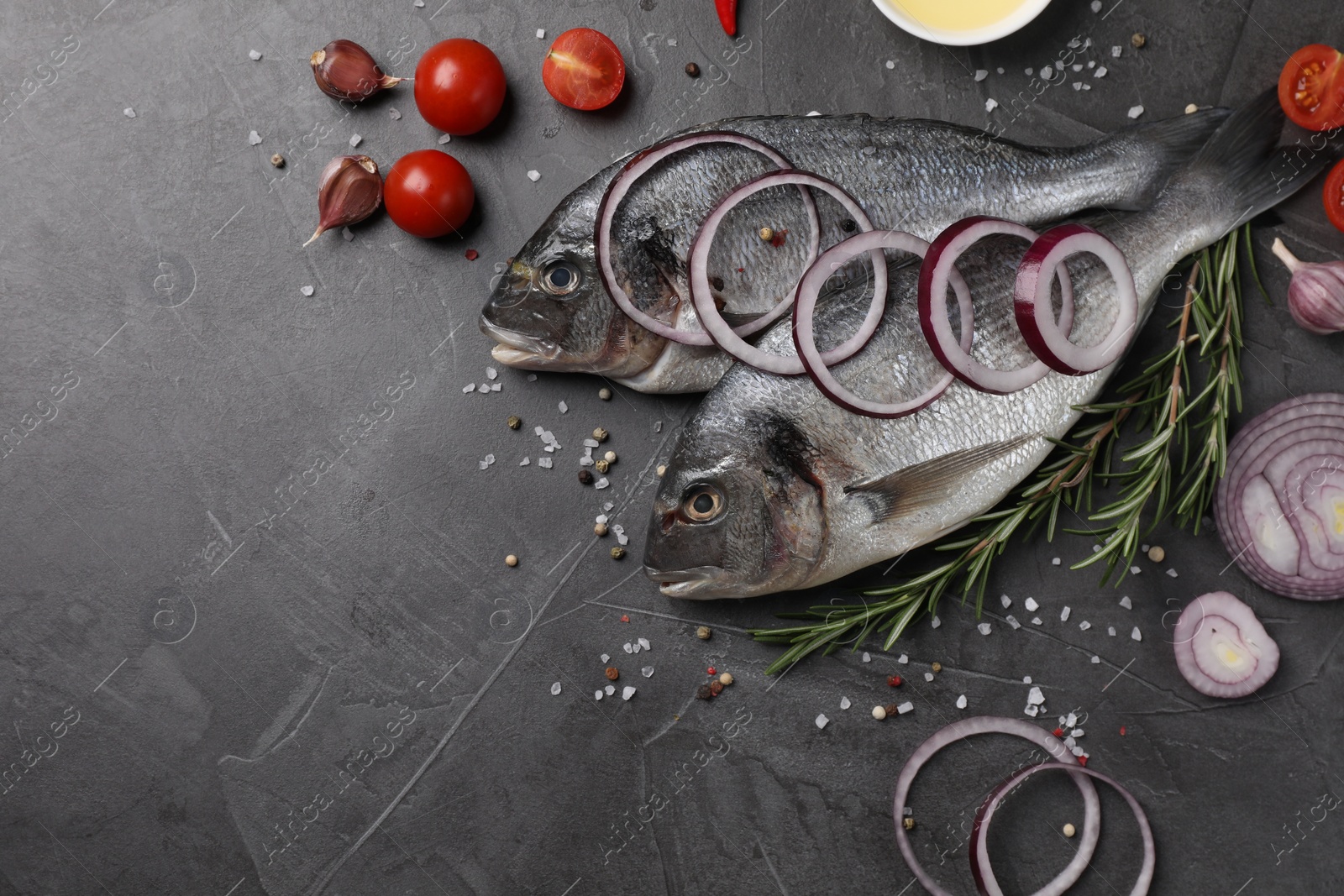 Photo of Fresh dorado fish and ingredients on grey table, flat lay. Space for text