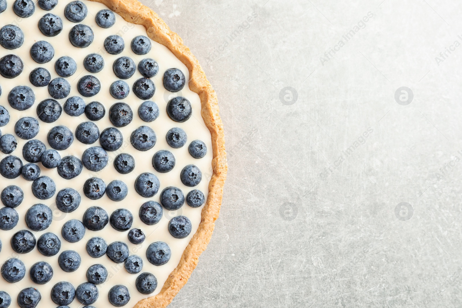 Photo of Tasty blueberry cake on gray background, top view with space for text