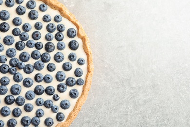 Tasty blueberry cake on gray background, top view with space for text