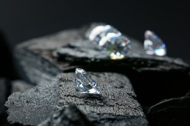 Photo of Beautiful shiny diamonds on coals, space for text