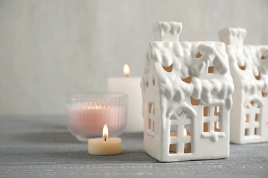 Composition with house shaped candle holders on grey wooden table, space for text. Christmas decoration