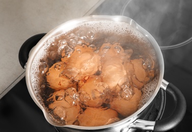 Cooking chicken eggs in pot on electric stove