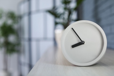 Photo of Analog alarm clock on table at home. Time of day