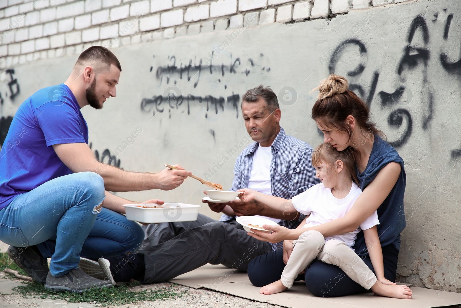 Photo of Poor people receiving food from volunteer outdoors