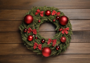 Photo of Beautiful Christmas wreath on wooden background, top view