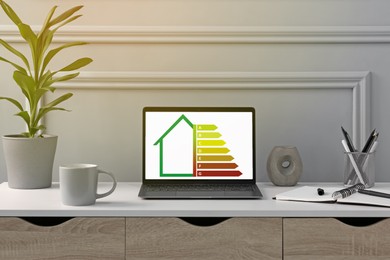 Image of Energy efficiency rating on laptop display. Workplace with modern computer