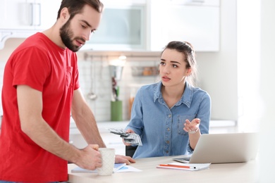 Young couple having argument about family budget in kitchen