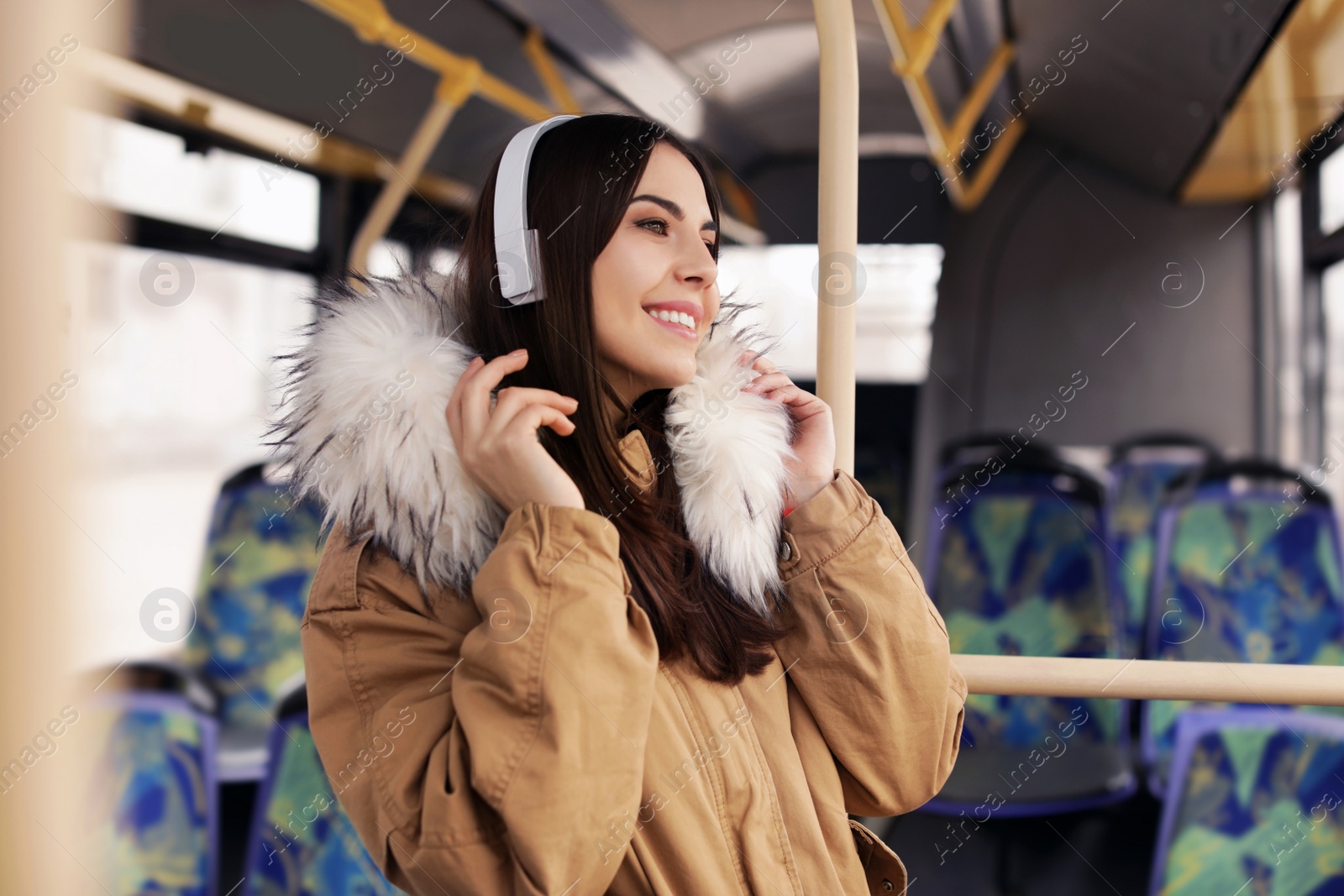 Photo of Young woman listening to music with headphones in public transport